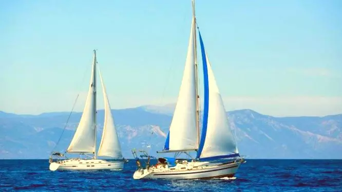 Two sailing boats sailing in the water image.